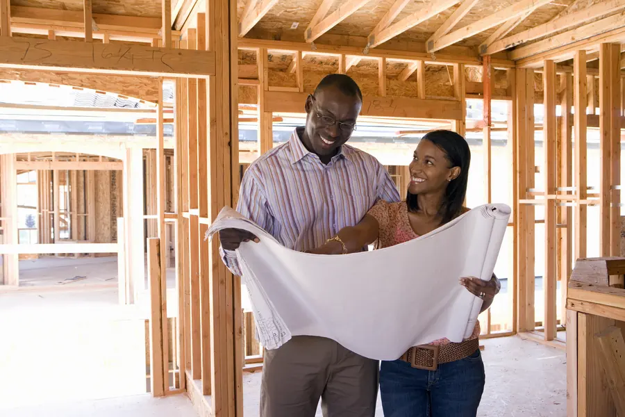 Couple reviews custom home construction plans as part of communication with contractor