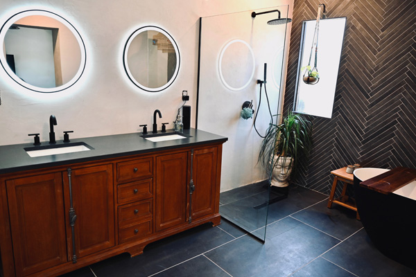 Double sink bathroom with dark tiles remodeling project performed by CactusNectar LLC