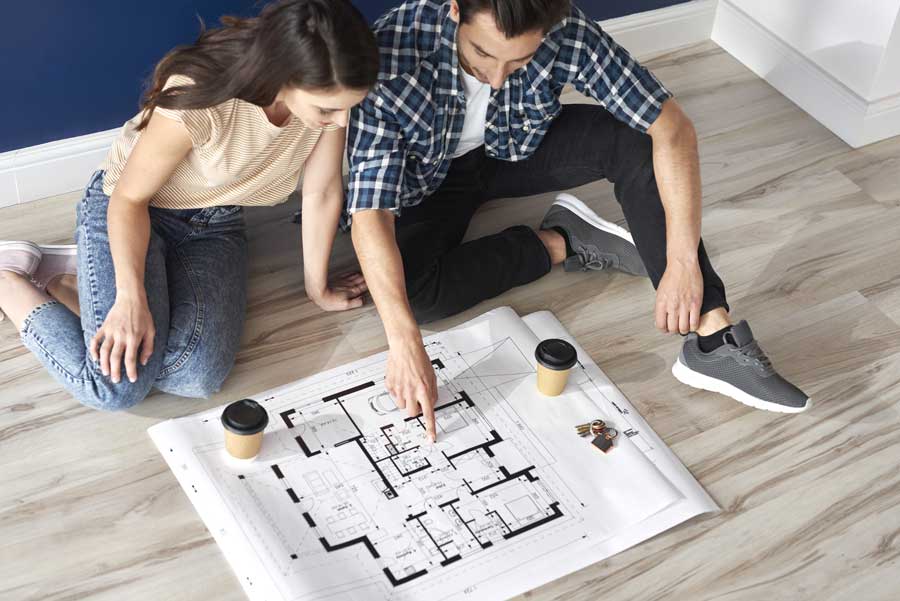 Couple looking at a blueprint of a guest home proyected by CactusNectar LLC, a general contractor un Tucson